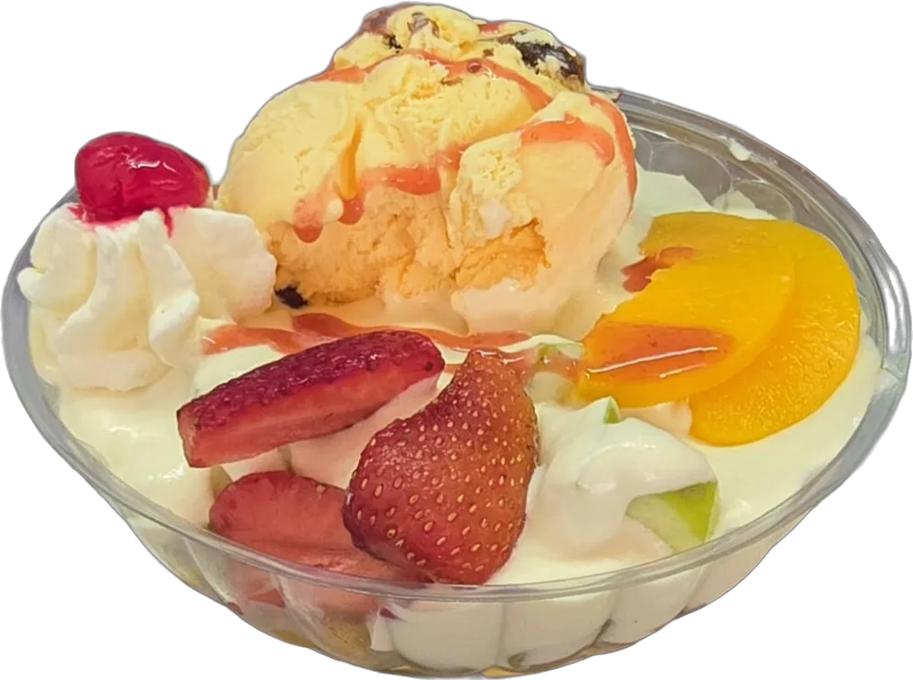 Ensalada de frutas con fresas, durazno, manzana verde, crema, bola de helado y cereza
